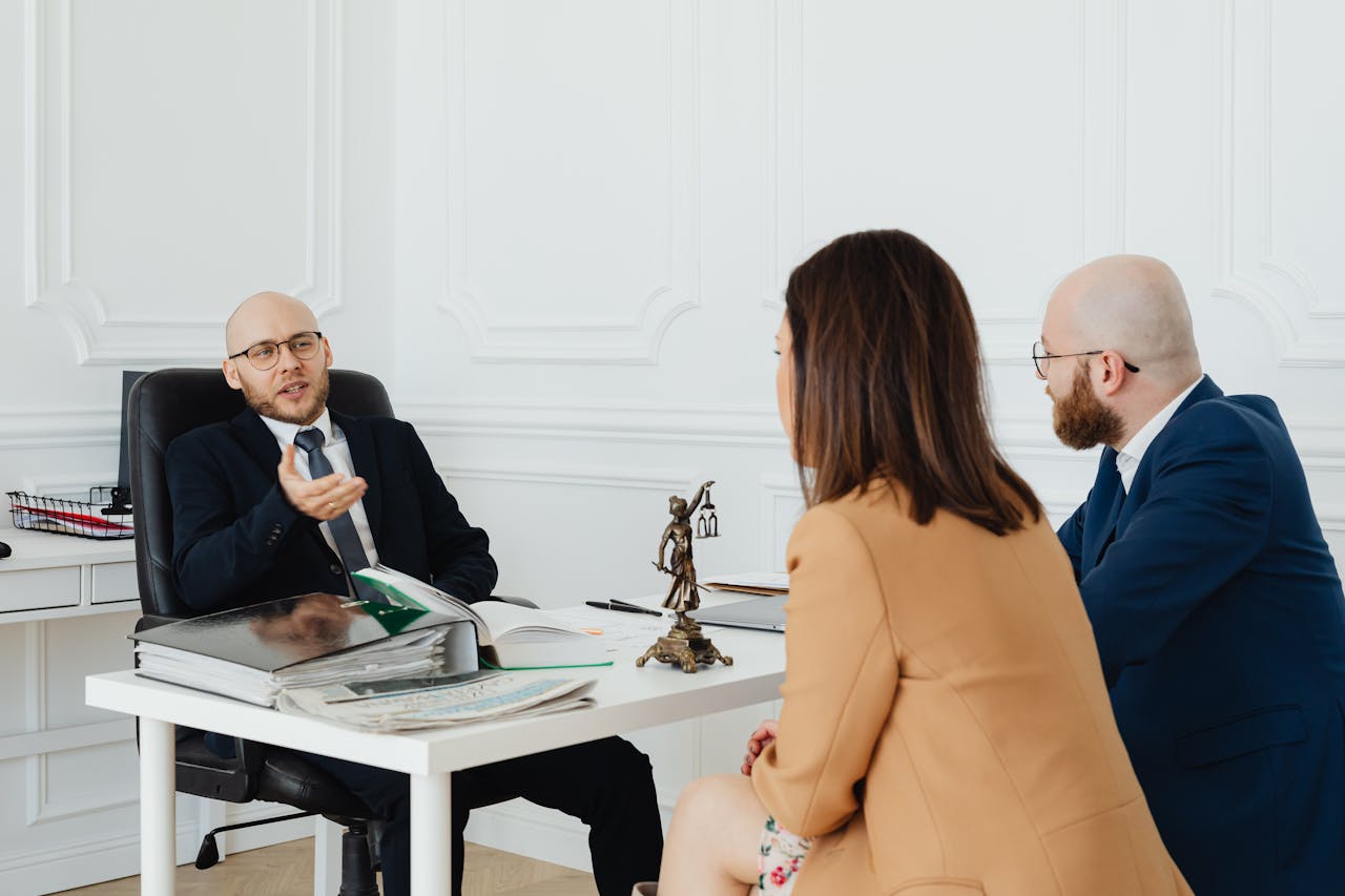 brand-02 Three adults in a formal business meeting discussing legal matters in an office.